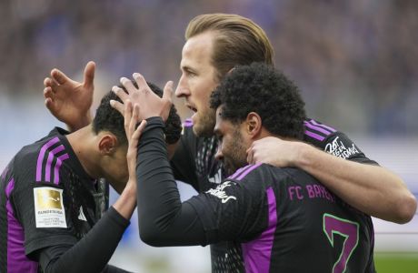 Bayern's Serge Gnabry, right, celebrates with his teammates Harry Kane, center, and Jamal Musiala after he scored his side's fourth goal during a German Bundesliga soccer match between SV Darmstadt 98 and Bayern Munich in Darmstadt, Germany, Saturday, March 16, 2024. (AP Photo/Michael Probst)