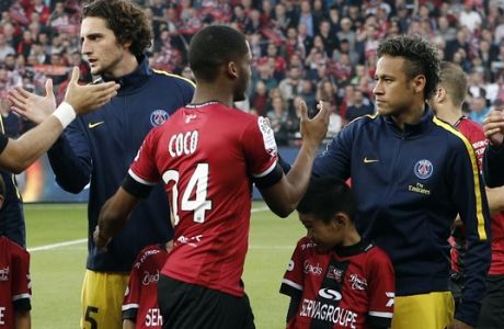 PSG's players Neymar, right, and Adrien Rabiot shake hands with Guingamp's players during the teams presentation before their French League One soccer match at the Roudourou stadium in Guingamp, western France, Sunday, Aug. 13, 2017. Neymar makes his long-awaited debut with Paris Saint-Germain on Sunday in the small Brittany town of Guingamp. French soccer authorities finally receive the Brazil star's international transfer certificate. (AP Photo/Kamil Zihnioglu)