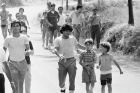 Argentine soccer star Diego Armando Maradona places his arm on a young fan while sightseeing after training with his new team Napoli of Naples in Castel Del Piano, Italy, on July 27, 1984. (AP Photo/Massimo Sambucetti)