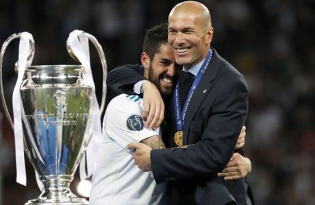 Real Madrid's Isco hugs coach Zinedine Zidane, right, after winning the Champions League Final soccer match between Real Madrid and Liverpool at the Olimpiyskiy Stadium in Kiev, Ukraine, Saturday, May 26, 2018. (AP Photo/Pavel Golovkin)