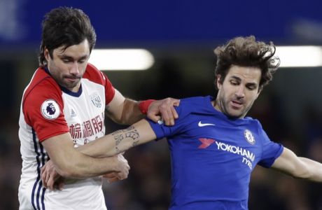 Chelsea's Cesc Fabregas, right, vies for the ball with West Bromwich Albion's Claudio Yacob during the English Premier League soccer match between Chelsea and West Bromwich Albion at Stamford Bridge stadium in London, Monday, Feb. 12, 2018. (AP Photo/Alastair Grant)