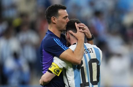 Argentina's head coach Lionel Scaloni kisses Argentina's Lionel Messi, right, at the end of the World Cup quarterfinal soccer match between the Netherlands and Argentina, at the Lusail Stadium in Lusail, Qatar, Saturday, Dec. 10, 2022. (AP Photo/Natacha Pisarenko)