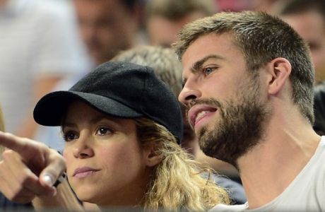 FILE - In this Sept. 9, 2014, file photo, FC Barcelona's player Gerard Pique, right, and Colombian singer Shakira attend a Basketball World Cup quarterfinal match between Slovenia and United States at the Palau Sant Jordi in Barcelona, Spain. Shakira announced Monday Jan. 19, 2014, that the couple celebrated a virtual baby shower through UNICEF to help poor children around the world. (AP Photo/Manu Fernandez, File)