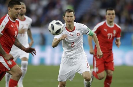 Switzerland's Stephan Lichtsteiner, centre, follows the ball during the group E match between Switzerland and Serbia at the 2018 soccer World Cup in the Kaliningrad Stadium in Kaliningrad, Russia, Friday, June 22, 2018. (AP Photo/Matthias Schrader)
