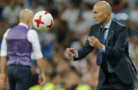 Real Madrid's head coach Zinedine Zidane throws the ball during the Santiago Bernabeu Trophy soccer match between Real Madrid and Fiorentina at the Santiago Bernabeu stadium in Madrid, Spain, Wednesday, Aug. 23, 2017. (AP Photo/Paul White)