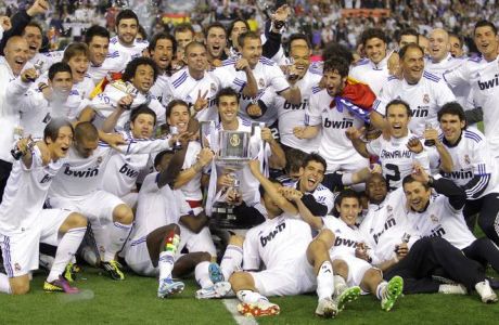 Real Madrid players celebrate with the trophy after beating FC Barcelona 1-0 during the final of the Copa del Rey soccer match at the Mestalla stadium in Valencia, Spain Wednesday April 20, 2011. (AP Photo/Andres Kudacki)
