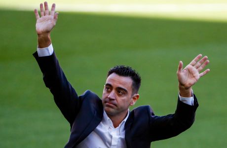 FC Barcelona's new signing coach Xavi Hernandez waves to the crowd during his official presentation at the Camp Nou stadium in Barcelona, Spain, Monday, Nov. 8, 2021. Xavi, who thrived in Barcelona's midfield alongside Messi and Andres Iniesta, was officially introduced as coach on the field of the Camp Nou with a reception usually only offered to top players. (AP Photo/Joan Monfort)
