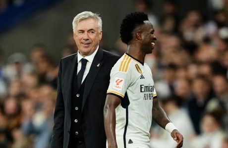 Real Madrid's head coach Carlo Ancelotti, left, smiles as Vinicius Junior leaves the pitch after a substitution during the Spanish La Liga soccer match between Real Madrid and Valencia at the Santiago Bernabeu stadium in Madrid, Spain, Saturday, Nov. 11, 2023. (AP Photo/Jose Breton)