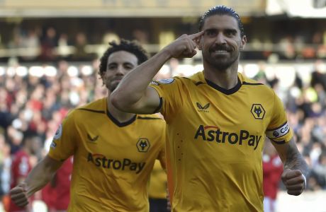 Wolverhampton Wanderers' Ruben Neves, right, celebrates after scoring his side's opening goal during the English Premier League soccer match between Wolverhampton Wanderers and Nottingham Forest at Molineux stadium in Wolverhampton, England, Saturday, Oct. 15, 2022. (AP Photo/Rui Vieira)