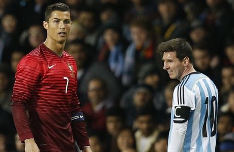 Cristiano Ronaldo of Portugal, left, and Lionel Messi of Argentina stand next to each other during their International Friendly soccer match at Old Trafford Stadium, Manchester, England, Tuesday Nov. 18, 2014. (AP Photo/Jon Super)  