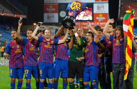 Barcelona's players lift up the Spanish King's Cup trophy with the jersey of team-mate Eric Abidal after winning their final soccer match against Athletic Bilbao at the Vicente Calderon stadium in Madrid, May 25, 2012.    REUTERS/Felix Ordonez (SPAIN  - Tags: SPORT SOCCER)  