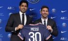 Lionel Messi, right, poses with his jersey with PSG president Nasser Al-Al-Khelaifi during a press conference Wednesday, Aug. 11, 2021 at the Parc des Princes stadium in Paris. Lionel Messi said he's been enjoying his time in Paris "since the first minute" after he signed his Paris Saint-Germain contract on Tuesday night. The 34-year-old Argentina star signed a two-year deal with the option for a third season after leaving Barcelona. (AP Photo/Francois Mori)