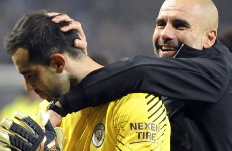 Manchester City manager Josep Guardiola, right, congratulates Manchester City's Claudio Bravo after he saved two penalties as Manchester City beat Leicester City on penalties during the League Cup Quarter Final soccer match between Leicester City and Manchester City at the King Power Stadium in Leicester, England, Tuesday, Dec. 19, 2017. (AP Photo/Rui Vieira)