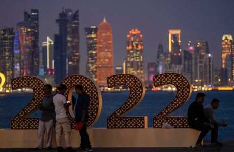 With the city skyline in the background, people pose for a photograph at the corniche in Doha, Qatar, Thursday, Nov. 17, 2022. Final preparations are being made for the soccer World Cup which starts on Nov. 20 when Qatar face Ecuador. (AP Photo/Hassan Ammar)