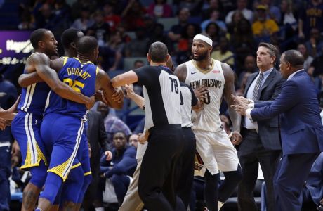 Golden State Warriors forward Kevin Durant and New Orleans Pelicans center DeMarcus Cousins (0) are restrained while going after each other during a scuffle in the second half of an NBA basketball game in New Orleans, Monday, Dec. 4, 2017. Both players were ejected from the game. (AP Photo/Gerald Herbert)