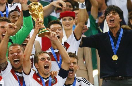 Germany's Philipp Lahm lifts the World Cup trophy as he celebrates with team mates and coach Joachim Loew (R) after winning the 2014 World Cup final against Argentina at the Maracana stadium in Rio de Janeiro in this July 13, 2014 file picture. Germany captain Philipp Lahm has decided to quit international soccer just days after leading his side to World Cup victory in Brazil, Bild newspaper reported on July 18, 2014.   REUTERS/Kai Pfaffenbach/File (BRAZIL  - Tags: SPORT SOCCER WORLD CUP) ORG XMIT: DHH183