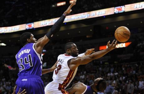 Miami Heat's Dwyane Wade (R) is defended by Sacramento Kings' Jason Thompson (L) during the first half of their NBA basketball game in Miami, Florida, February 21, 2012.   REUTERS/Rhona Wise   (UNITED STATES - Tags: SPORT BASKETBALL)