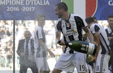 Juventus' Leonardo Bonucci sprays sparkling wine as Juventus players celebrate winning an unprecedented sixth consecutive Italian title, at the end of the Serie A soccer match between Juventus and Crotone at the Juventus stadium, in Turin, Italy, Sunday, May 21, 2017. (AP Photo/Antonio Calanni)