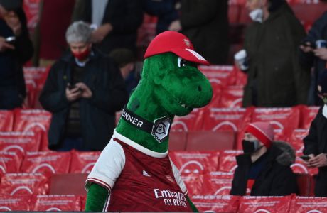 The Arsenal mascot walks by as a number of home fans sit waiting for the start of an English Premier League soccer match between Arsenal and Burnley at the Emirates stadium in London, England, Sunday Dec. 13, 2020. (Laurence Griffiths/Pool via AP)