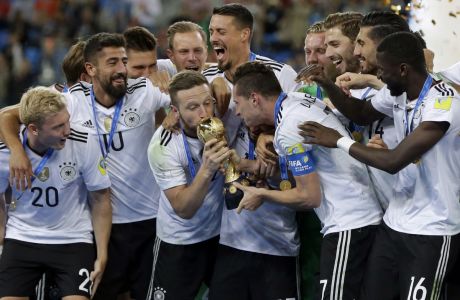 Germany's Shkodran Mustafi kisses the trophy held by Julian Draxler after winning the Confederations Cup final soccer match between Chile and Germany, at the St.Petersburg Stadium, Russia, Sunday July 2, 2017. Germany won 1-0. (AP Photo/Thanassis Stavrakis)