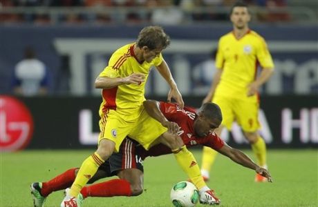 Trinidad and Tobago's Andre Boucaud, right, challenges for the ball with Romania's Costin Lazar, left, during a friendly soccer match on the National Arena stadium in Bucharest, Romania, Tuesday, June 4, 2013.(AP Photo/Vadim Ghirda)