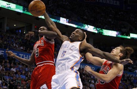 Oklahoma City Thunder center Kendrick Perkins (C) goes for the ball between Chicago Bulls small forward Luol Deng and center Joakim Noah (R) during their NBA basketball game in Oklahoma City, Oklahoma, April 1, 2012. REUTERS/Bryan Terry (UNITED STATES - Tags: SPORT BASKETBALL)