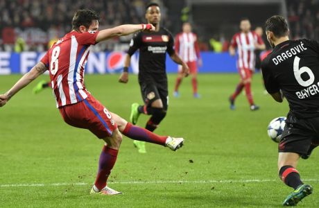 Atletico's Saul Niguez, left, scores the opening goal past Leverkusen's Aleksandar Dragovic, right, during the Champions League round of 16 first leg soccer match between Bayer Leverkusen and Atletico Madrid in Leverkusen, Germany, Tuesday, Feb. 21, 2017. (AP Photo/Martin Meissner)
