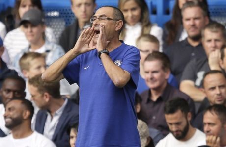 Chelsea head coach Maurizio Sarri, right, shouts while Arsenal manager Unai Emery, center, sits down on the bench during the English Premier League soccer match between Chelsea and Arsenal at Stamford bridge stadium in London, Saturday, Aug. 18, 2018. (AP Photo/Tim Ireland)