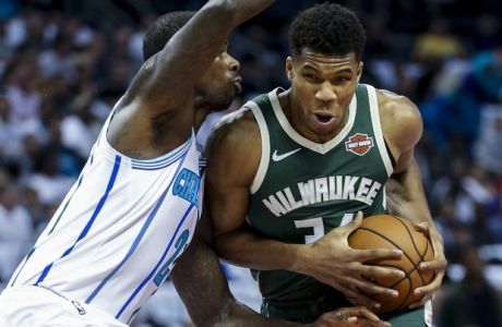Milwaukee Bucks forward Giannis Antetokounmpo, right, of Greece, drives into Charlotte Hornets forward Marvin Williams in the first half of an NBA basketball game in Charlotte, N.C., Wednesday, Oct. 17, 2018. (AP Photo/Nell Redmond)