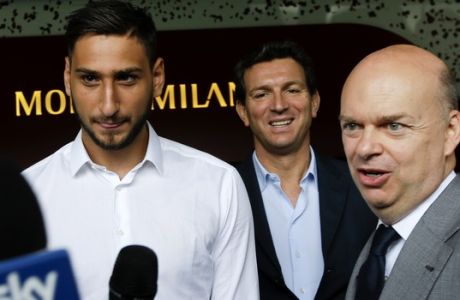 AC Milan goalie Gianluigi Donnarumma, left, is flanked by team CEO Marco Fassone at the 'Casa Milan', AC Milan team headquarters, in Milan Italy, Wednesday, July 12, 2017. AC Milan's teenage goalkeeper Gianluigi Donnarumma has agreed to extend his contract with the Serie A club until 2021. The talented 18-year-old turned down a new deal last month and would have been a free agent at the end of next season. On Tuesday, Milan announced it had reached an agreement with Donnarumma, saying he would sign a new four-year contract the following morning. (AP Photo/Luca Bruno)