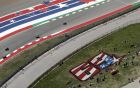 Fans sit near a tribute to Nicky Hayden as they watch a practice session for the Grand Prix of the Americas motorcycle race at the Circuit Of The Americas, Friday, April 12, 2019, in Austin, Texas. MotoGP has retired Hayden's No. 69. (AP Photo/Eric Gay)