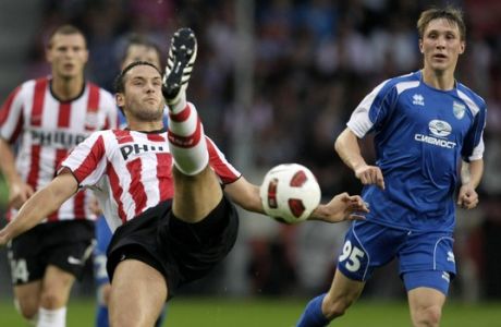 PSV Eindhoven player Jagos Vukovic, left, clears the ball as Sibir player Roman Belyaev, right, looks on during the Europa League qualifying round soccer match PSV versus Sibir Novosibirsk at Philips stadium in Eindhoven, Netherlands, Thursday Aug. 26, 2010. (AP Photo/Peter Dejong)