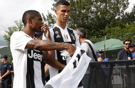 Juventus' Cristiano Ronaldo, right, talks with his teammate Douglas Costa prior to the start of a friendly soccer match between the Juventus A and B teams, in Villar Perosa, near Turin, Italy, Sunday, Aug.12, 2018. (AP Photo/Antonio Calanni)