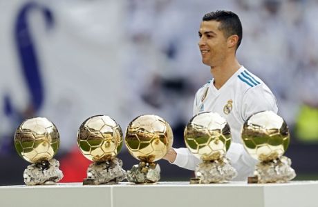 Real Madrid's Cristiano Ronaldo poses for the media with his five Golden Ball trophies prior the Spanish La Liga soccer match between Real Madrid and Sevilla at the Santiago Bernabeu stadium in Madrid, Saturday, Dec. 9, 2017. Ronaldo scored twice in Real Madrid's 5-0 victory. (AP Photo/Francisco Seco)