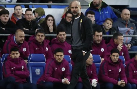 Manchester City coach Pep Guardiola walks in front of the bench during the English FA Cup fourth round soccer match between Cardiff City and Manchester City at Cardiff City stadium in Cardiff, Wales, Sunday, Jan. 28, 2018. (AP Photo/Kirsty Wigglesworth)