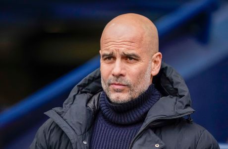 Manchester City's head coach Pep Guardiola looks out from the bench prior the English Premier League soccer match between Manchester City and Arsenal at the Etihad stadium in Manchester, England, Sunday, March 31, 2024. (AP Photo/Dave Thompson)