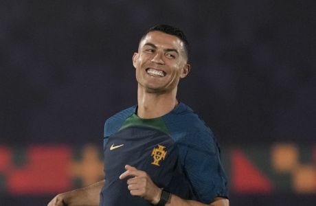 Portugal's Cristiano Ronaldo smiles as he warms up during the Portugal's official training on the eve of the group H World Cup soccer match between Portugal and Ghana at the Al Shahaniya SC training site in Al Shahaniya, Qatar, Wednesday, Nov. 23, 2022. (AP Photo/Lee Jin-man)