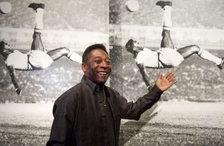 Brazilian football legend Pele poses for photographers in front of a painting entitled "Pele, Bicycle Kick" by artist Russell Young, during a press preview to promote the forthcoming exhibition "Pele: Art, Life, Football" at the Halcyon Gallery in London on September 22, 2015. The exhibition, which features works from artists Andy Warhol, Lorenzo Quinn, Pedro Paricio, will also feature memorabilia from the course of Pele's career, including his first football. Pele: Art, Life, Football is set to run until October 18, 2015.   AFP PHOTO / JUSTIN TALLIS  RESTRICTED TO EDITORIAL USE, MANDATORY MENTION OF THE ARTIST UPON PUBLICATION, TO ILLUSTRATE THE EVENT AS SPECIFIED IN THE CAPTIONJUSTIN TALLIS/AFP/Getty Images