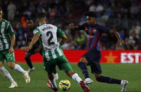 Barcelona's Lamine Yamal, right, is challenged by Betis' Martin Montoya during a Spanish La Liga soccer match between Barcelona and Real Betis at the Camp Nou stadium in Barcelona, Spain, Saturday, April 29, 2023. (AP Photo/Joan Monfort)