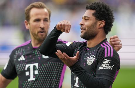 Bayern's Serge Gnabry, right, celebrates with his teammate Harry Kane after he scored his side's fourth goal during a German Bundesliga soccer match between SV Darmstadt 98 and Bayern Munich in Darmstadt, Germany, Saturday, March 16, 2024. (AP Photo/Michael Probst)