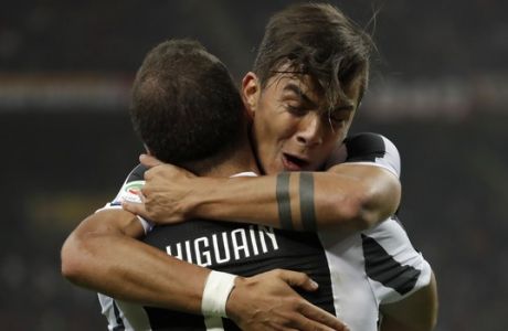 Juventus' Paulo Dybala hugs teammate Gonzalo Higuain who scored his side's first goal during a Serie A soccer match between AC Milan and Juventus, at the Milan San Siro stadium, Italy, Saturday, Oct. 28, 2017. (AP Photo/Luca Bruno)