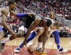 Houston Rockets center Clint Capela, middle, battles for a loose ball between Dallas Mavericks forward Harrison Barnes, left, and Dallas Mavericks forward Luka Doncic, right, during the second half of an NBA basketball game, Wednesday, Nov. 28, 2018, in Houston. (AP Photo/Michael Wyke)