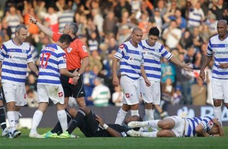 Referee Chris Foy, third left, sends off Chelsea's Didier Drogba, left on ground, for a tackle on Queens Park Rangers' Adel Taarabt, right on ground during their English Premier League soccer match at Loftus Road stadium, London, Sunday, Oct. 23, 2011. (AP Photo/Sang Tan)