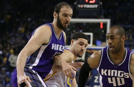Sacramento Kings' Arron Afflalo, right, drives the ball around Golden State Warriors' Klay Thompson, center, who is blocked by Kings' Kosta Koufos during the first half of an NBA basketball game Friday, March 24, 2017, in Oakland, Calif. (AP Photo/Ben Margot)