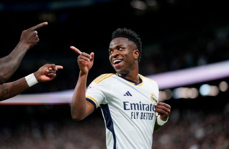 FILE - Real Madrid's Vinicius Junior celebrates after scoring his side's first goal during a Spanish La Liga soccer match between Real Madrid and Celta Vigo at the Santiago Bernabeu stadium in Madrid, Spain, on March 10, 2024. Real Madrid has filed a complaint with Spanish state prosecutors asking them to investigate the reported racist chants aimed at forward Vinícius Júnior outside the stadiums of Atletico Madrid and Barcelona before their Champions League games this week. Madrid said Friday March 15, 2024 that it asked the prosecutors to request footage from security cameras outside the two stadiums in order to identify the authors of the racist insults and hate speech. (AP Photo/Manu Fernandez, File)