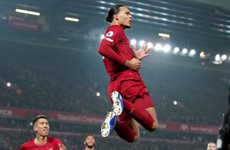 Liverpool's Virgil van Dijk jumps to celebrate scoring his side's first goal during the English Premier League soccer match between Liverpool and Manchester United at Anfield Stadium in Liverpool, Sunday, Jan. 19, 2020.(AP Photo/Jon Super)