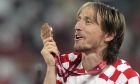 Croatia's Luka Modric shows the bronze medal and celebrates at the end of the World Cup third-place playoff soccer match between Croatia and Morocco at Khalifa International Stadium in Doha, Qatar, Saturday, Dec. 17, 2022. (AP Photo/Frank Augstein)