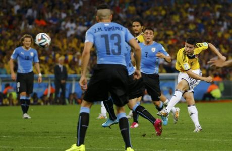 Colombia's James Rodriguez (R) shoots to score a goal against Uruguay during their 2014 World Cup round of 16 game at the Maracana stadium in Rio de Janeiro June 28, 2014. REUTERS/Pilar Olivares (BRAZIL  - Tags: SOCCER SPORT WORLD CUP TPX IMAGES OF THE DAY)