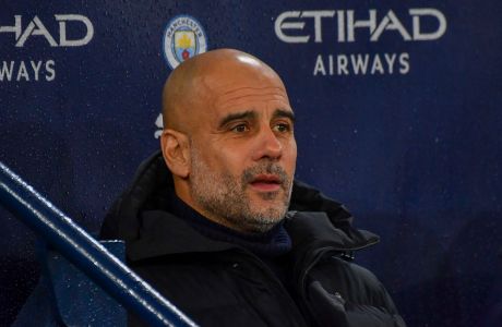 Manchester City's head coach Pep Guardiola looks out from the bench prior the English Premier League soccer match between Manchester City and Brentford at the Etihad stadium in Manchester, England, Tuesday, Feb. 20, 2024. (AP Photo/Rui Vieira)