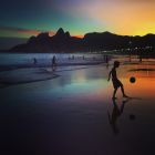 RIO DE JANEIRO, BRAZIL - JUNE 08: (EDITORS NOTE: THIS IMAGE HAS BEEN CREATED WITH THE USE OF DIGITAL FILTERS) A young boy plays football at sunset on June 8, 2014 in Rio de Janeiro, Brazil. (Photo by Clive Rose/Getty Images)